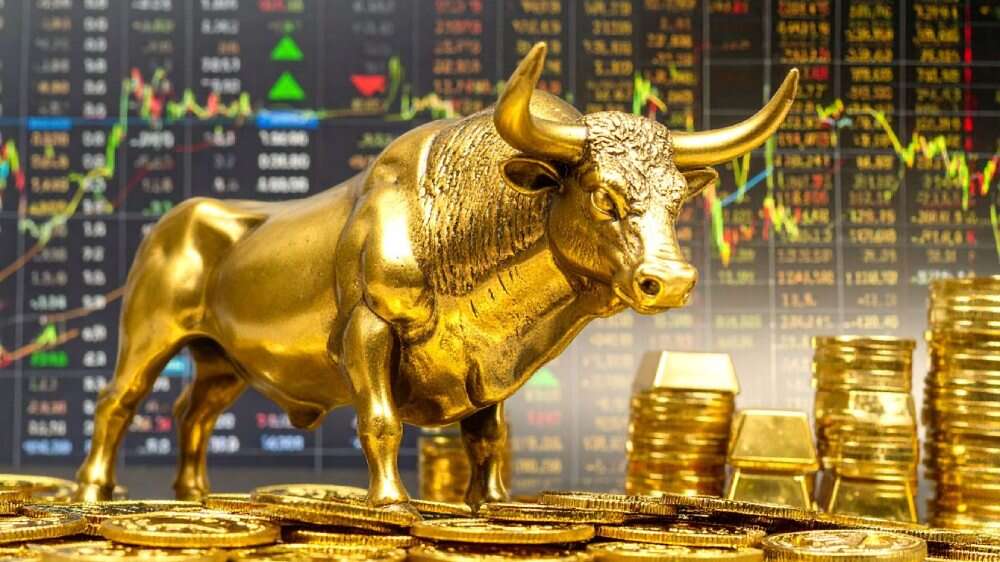 مجسمه گاو طلایی روی سکه‌ها با نماد بازار صعودی بورس در پس‌زمینه
