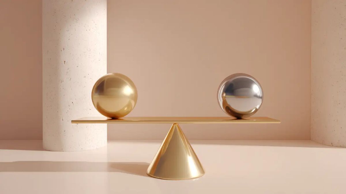 یک ترازو طلایی روی سطحی صاف قرار دارد که روی یک کفه آن گوی طلایی و کفه دیگر گوی نقرهای قرار دارد.