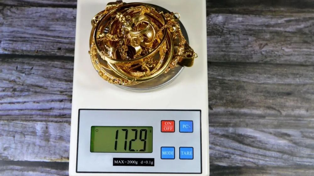 طلای شکسته روی ترازو با وزن ۱۲۷.۹ گرم