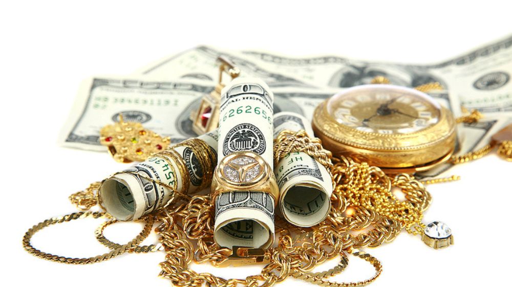 طلای شکسته در کنار رولهایی از دلار