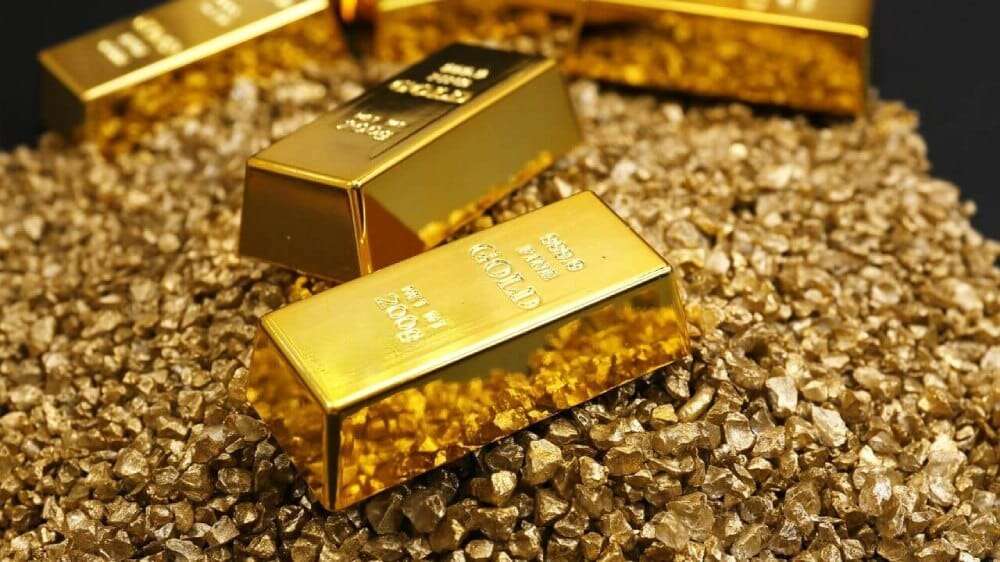 شمش‌های طلای درخشان روی توده‌ای از خرده‌های طلای خالص
