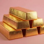 انباشته‌ای از شمش‌های طلای براق در اتاقی با نور ملایم پاستلی